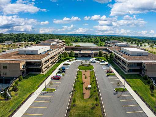 A large, modern building complex with a parking lot in front. at The Residences at Tesson Ridge Apartments, Missouri, 63128