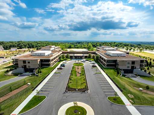 A large, modern building complex with a parking lot in front. at The Residences at Tesson Ridge Apartments, Missouri