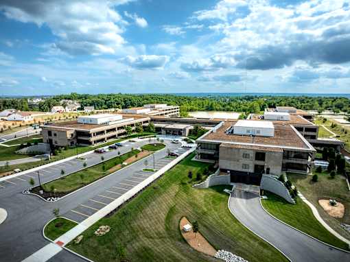 A large building complex with a parking lot in front. at The Residences at Tesson Ridge Apartments, Saint Louis, Missouri