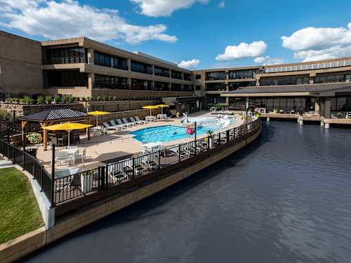 A large building with a pool and a waterway in front. at The Residences at Tesson Ridge Apartments, Missouri