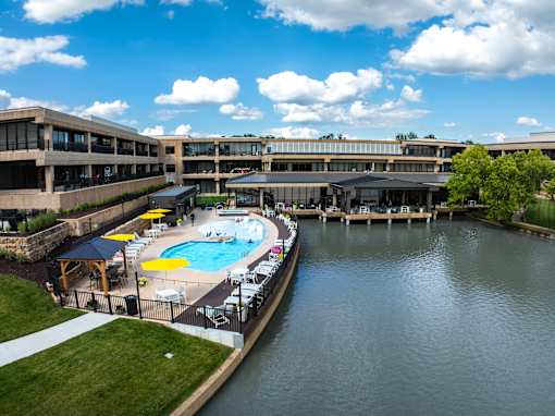 A large building with a pool in front of it. at The Residences at Tesson Ridge Apartments, Missouri, 63128