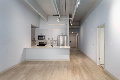 A spacious kitchen with a white countertop and wooden flooring. at The Residences at Tesson Ridge Apartments, Saint Louis