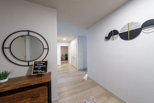 A hallway with a mirror and a sign at The Residences at Tesson Ridge Apartments, Saint Louis, MO, 63128