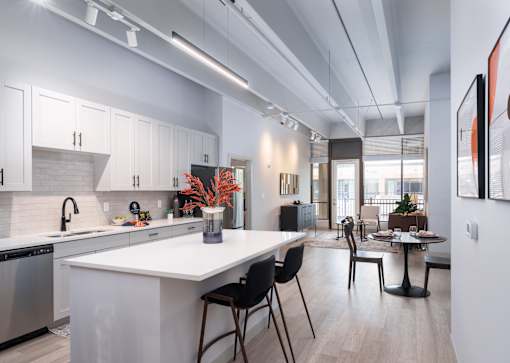 A modern kitchen with white cabinets and a large island. at The Residences at Tesson Ridge Apartments, Missouri