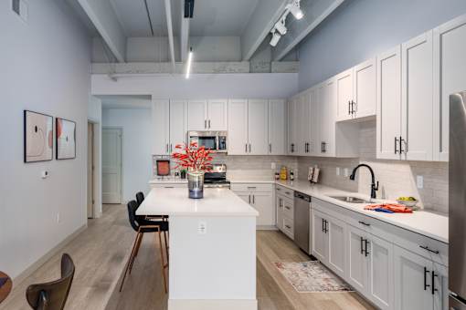 A kitchen with white cabinets and a white island. at The Residences at Tesson Ridge Apartments, Saint Louis, Missouri