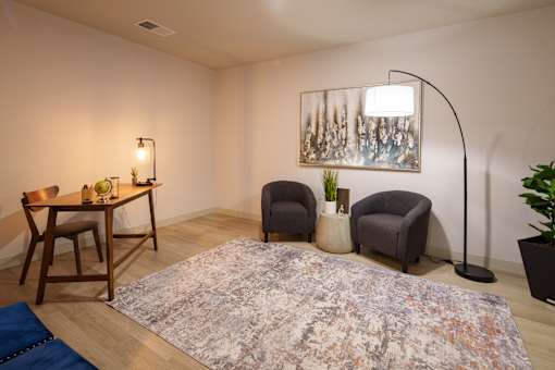 A room with a rug, a table with chairs, a floor lamp, and a painting on the wall. at The Residences at Tesson Ridge Apartments, Missouri, 63128