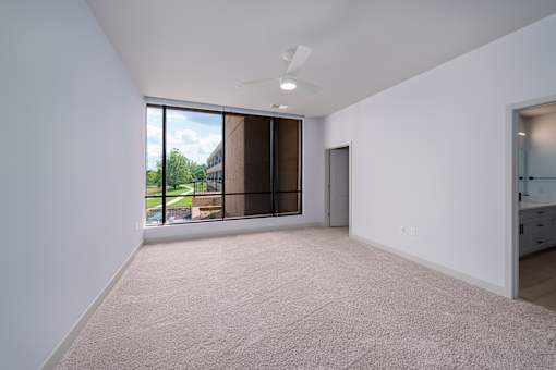 A large empty room with a window overlooking a building. at The Residences at Tesson Ridge Apartments, Saint Louis, MO