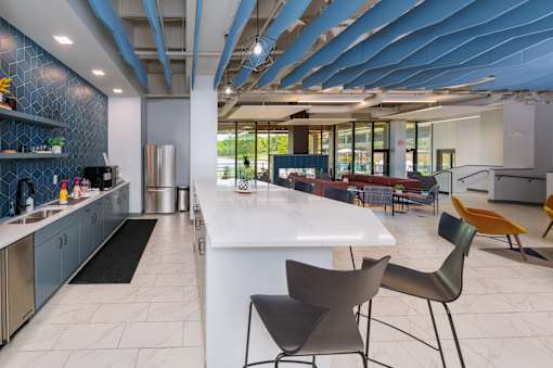 A modern kitchen with a white island and black chairs. at The Residences at Tesson Ridge Apartments, Saint Louis, MO, 63128