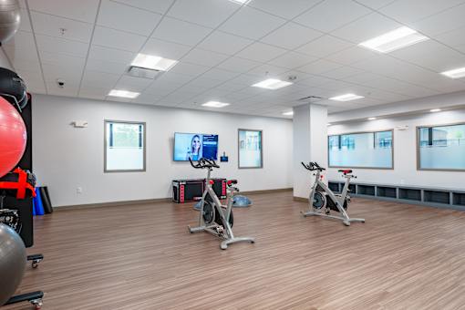 A gym with exercise bikes and a television. at The Residences at Tesson Ridge Apartments, Saint Louis, MO, 63128