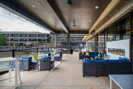 A patio area with blue couches and tables. at The Residences at Tesson Ridge Apartments, Saint Louis, MO, 63128
