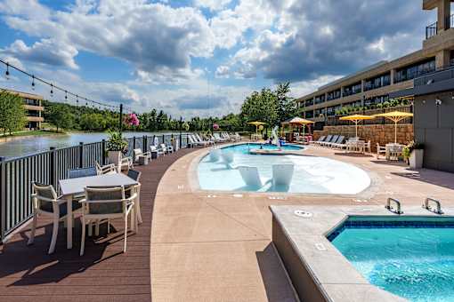 A large outdoor pool area with a hot tub and lounge chairs. at The Residences at Tesson Ridge Apartments, Saint Louis, 63128
