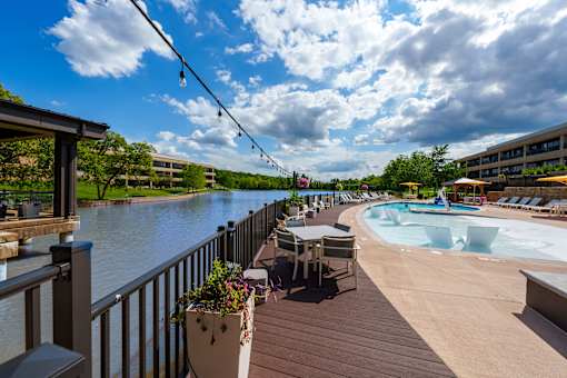 A pool area with a hot tub and a view of a river. at The Residences at Tesson Ridge Apartments, Saint Louis, MO