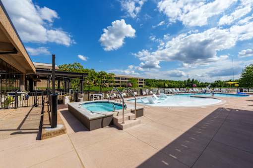 A large outdoor swimming pool with a hot tub and a water slide. at The Residences at Tesson Ridge Apartments, Missouri, 63128