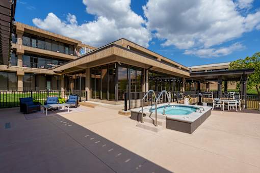 A large outdoor swimming pool area with a building in the background. at The Residences at Tesson Ridge Apartments, Missouri