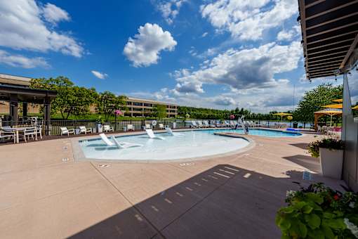A large outdoor swimming pool with a fountain in the middle. at The Residences at Tesson Ridge Apartments, Saint Louis
