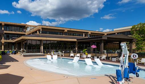 A large outdoor swimming pool with loungers and a building in the background. at The Residences at Tesson Ridge Apartments, Saint Louis, MO