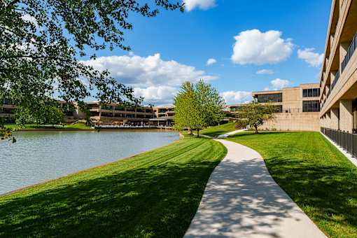 A pathway runs alongside a body of water. at The Residences at Tesson Ridge Apartments, Saint Louis, MO, 63128