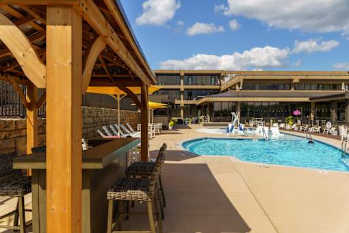 A pool area with a wooden structure and chairs. at The Residences at Tesson Ridge Apartments, Saint Louis, 63128