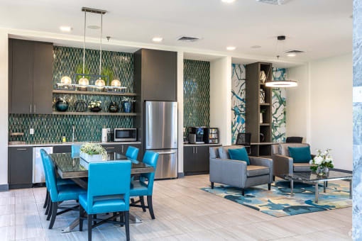 a living room and kitchen with blue chairs and a table
