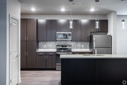 a modern kitchen with stainless steel appliances and dark wood cabinets