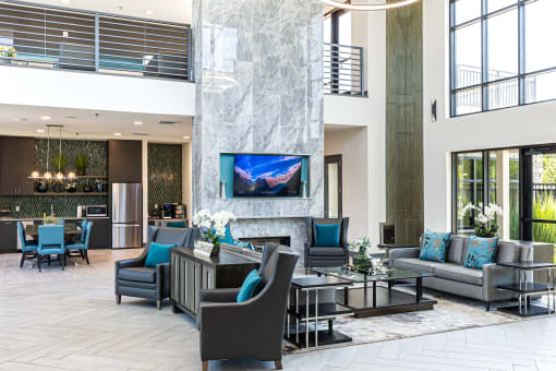 a lobby with couches chairs and tables and a fireplace