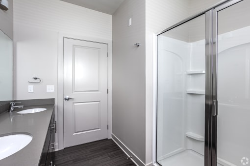 a bathroom with a shower and a sink and a mirror