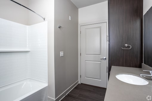 a small bathroom with a toilet and a shower in a room with a wooden floor