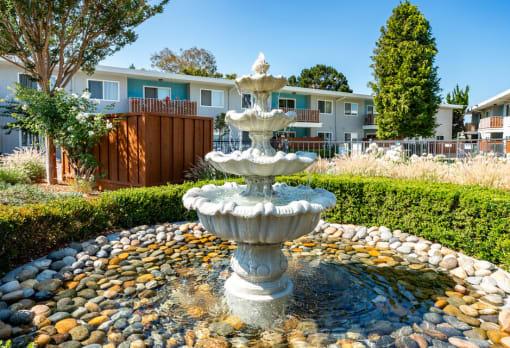 a fountain in front of an apartment complex