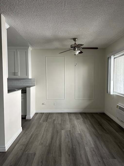 A bathroom with a white tub and a ceiling fan.
