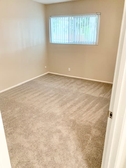 an empty room with carpet and a window