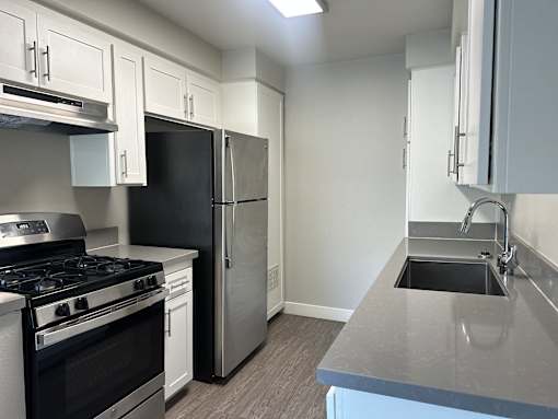 A kitchen with a black stove top oven and a black refrigerator.