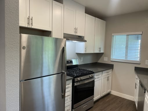 a kitchen with white cabinets and stainless steel appliances