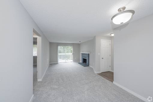 A spacious living room with a fireplace and sliding glass doors.