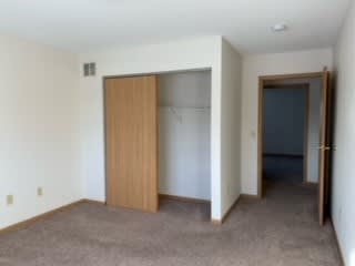 an empty room with an open door and a closet