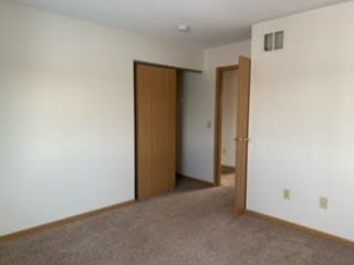 a room with an open door and a carpeted floor