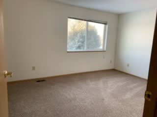 an empty room with a window and a door
