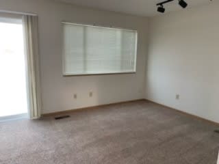 an empty room with a window and a window shade