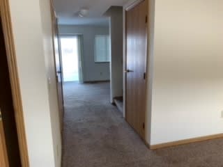 a hallway with a door and a closet
