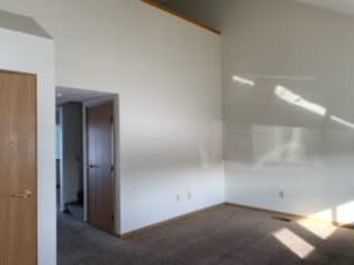 an empty room with white walls and a wooden door