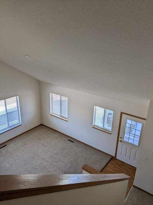 a view of a living room from the top of the stairs