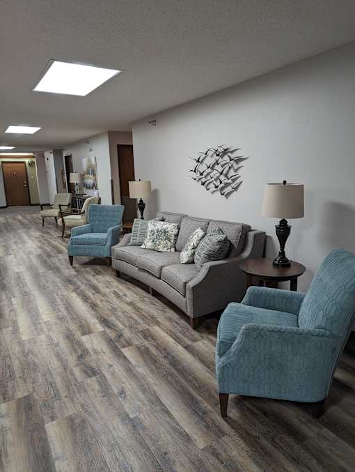 a living room with a couch chairs and lamps