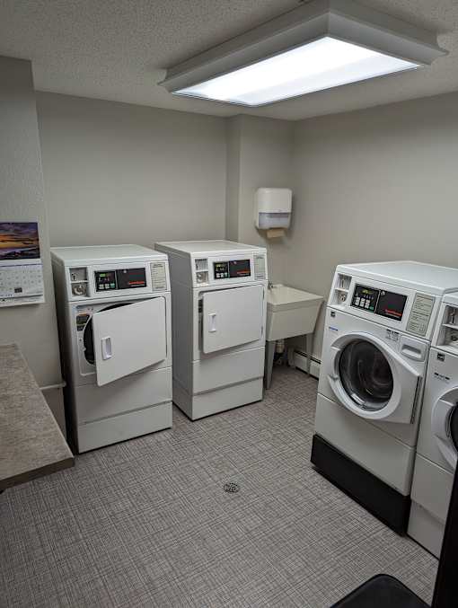 a laundry room with three washers and two dryers