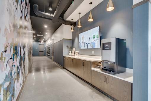 A long hallway with a wall of pictures on the left and a counter with a coffee maker on the right. at The Shale, Minnesota