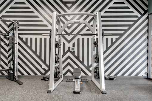 A gym with a weight bench and a squat rack. at The Shale, Minneapolis, 55406