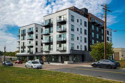 A modern apartment building with cars parked in front. at The Shale, Minnesota, 55406