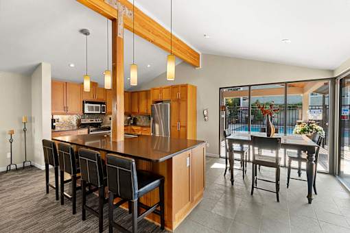 A kitchen with a long island and chairs.