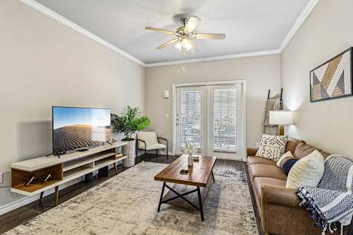 A living room with a flat screen TV and a brown couch.