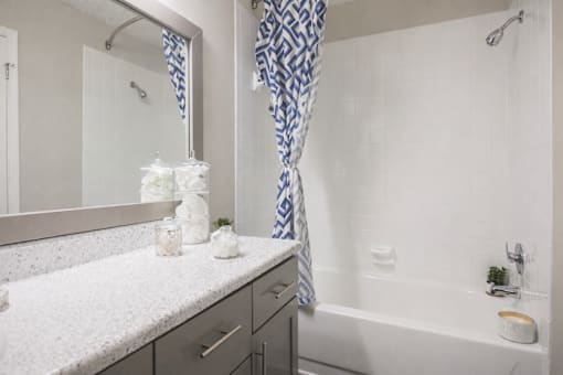 A white bathroom with a blue and white shower curtain.