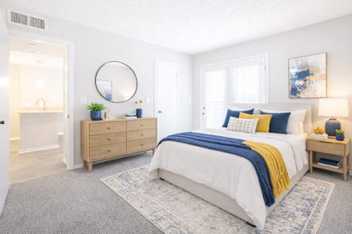 A bedroom with a bed, dresser, and mirror.