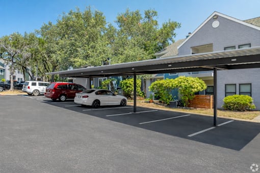 A parking lot with cars and a building in the background.